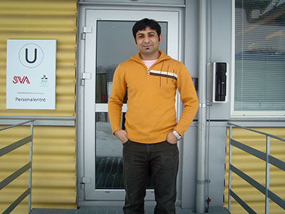 Professor Munir standing in front of a door
