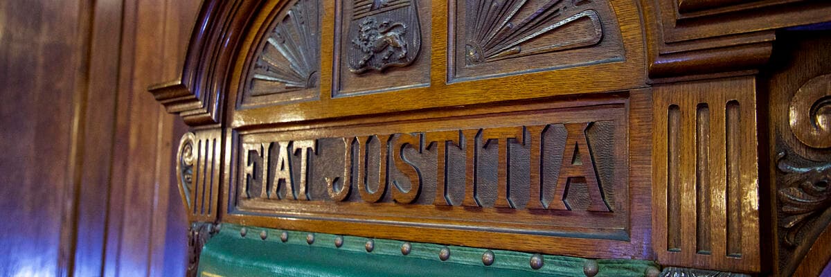 Law mock court room bench with words Fiat justitia 