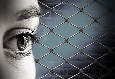 persons eye against a wired fence background