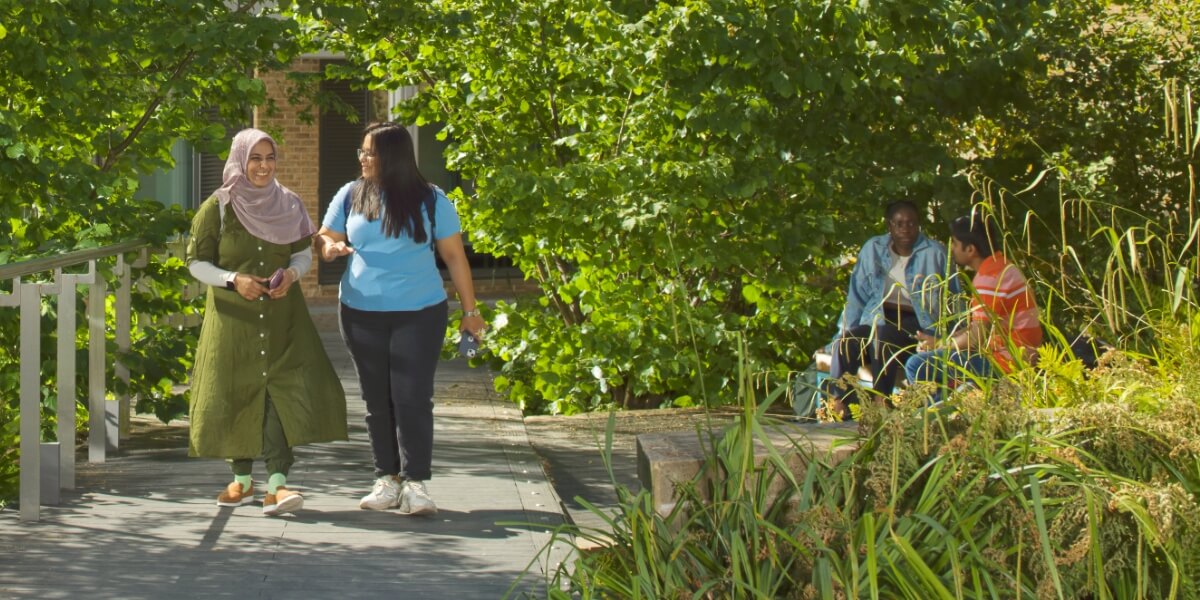 Students walking through the greenery by the Great Hall